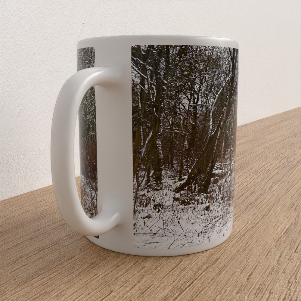 White mug with a forest design on a wooden surface