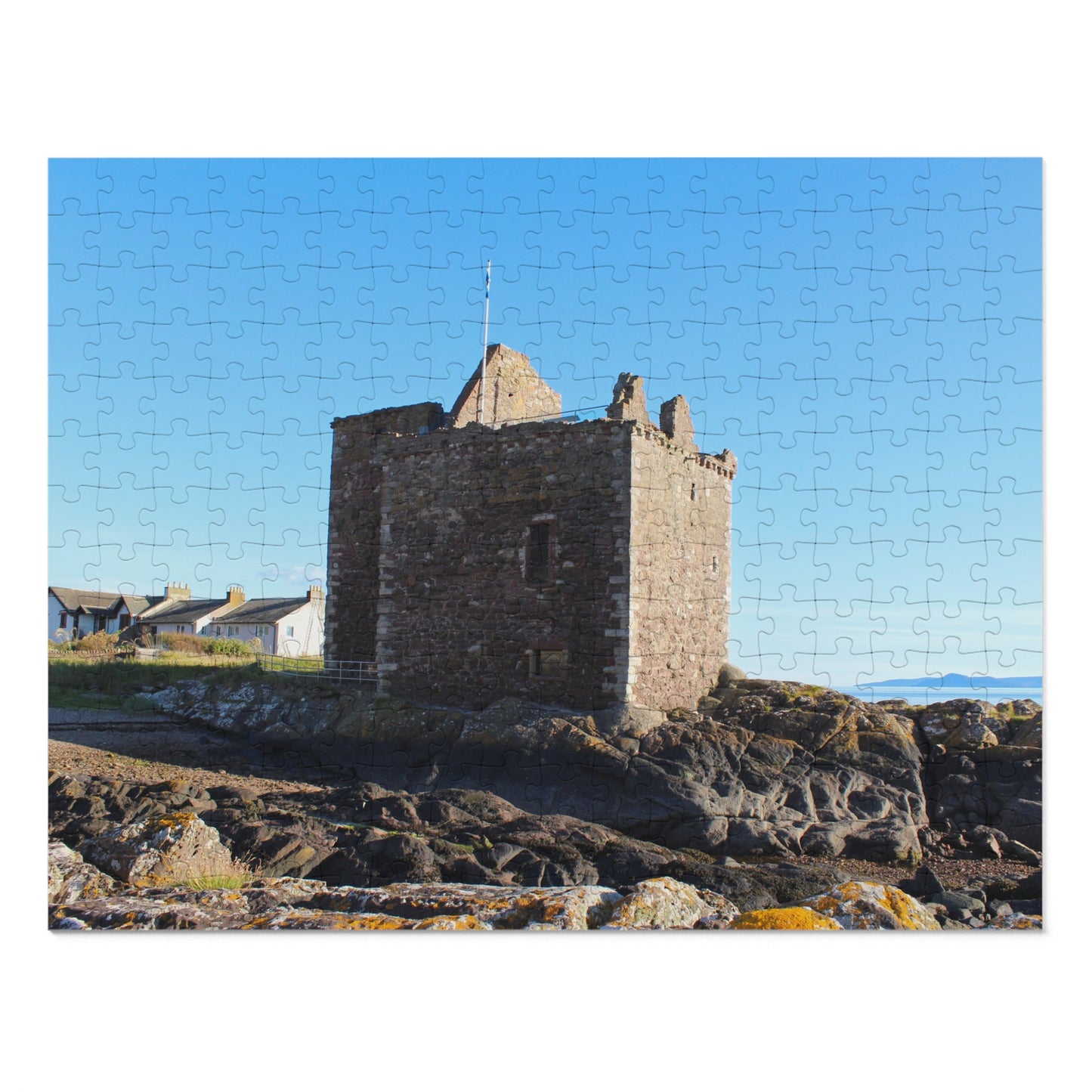 Jigsaw puzzle with a castle on a rocky outcrop against a blue sky.