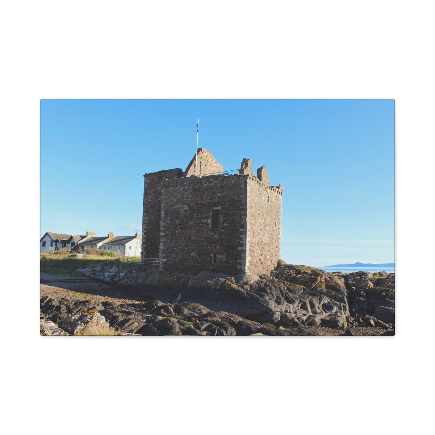 Stone tower on a rocky outcrop with a clear blue sky