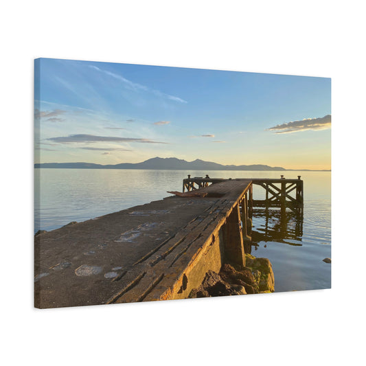 Canvas print of a dock by a body of water with mountains in the background
