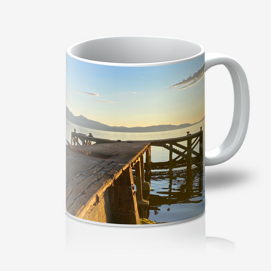 Mug with a scenic design of a dock and mountains on a white background
