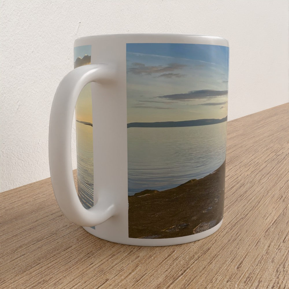 Mug with a scenic design of a landscape on a wooden surface