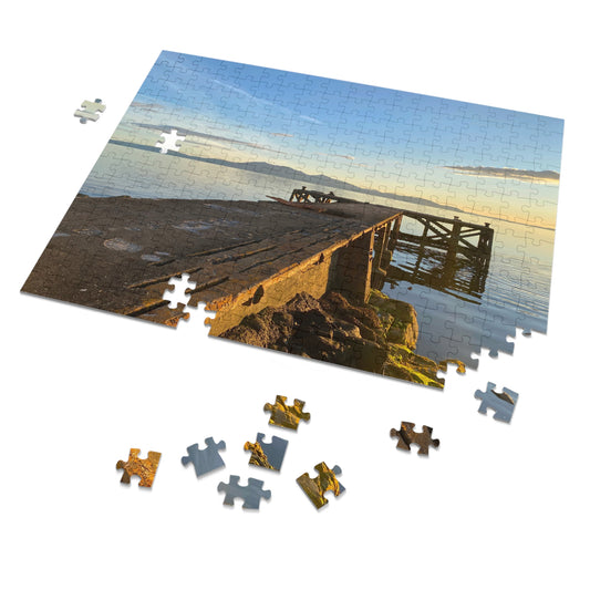 Jigsaw puzzle with a completed section showing a dock at sunset, with missing pieces on a white background.
