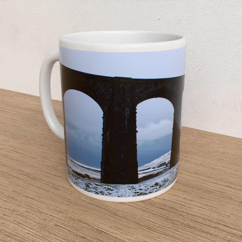 Mug with a design of a black archway on a wooden surface