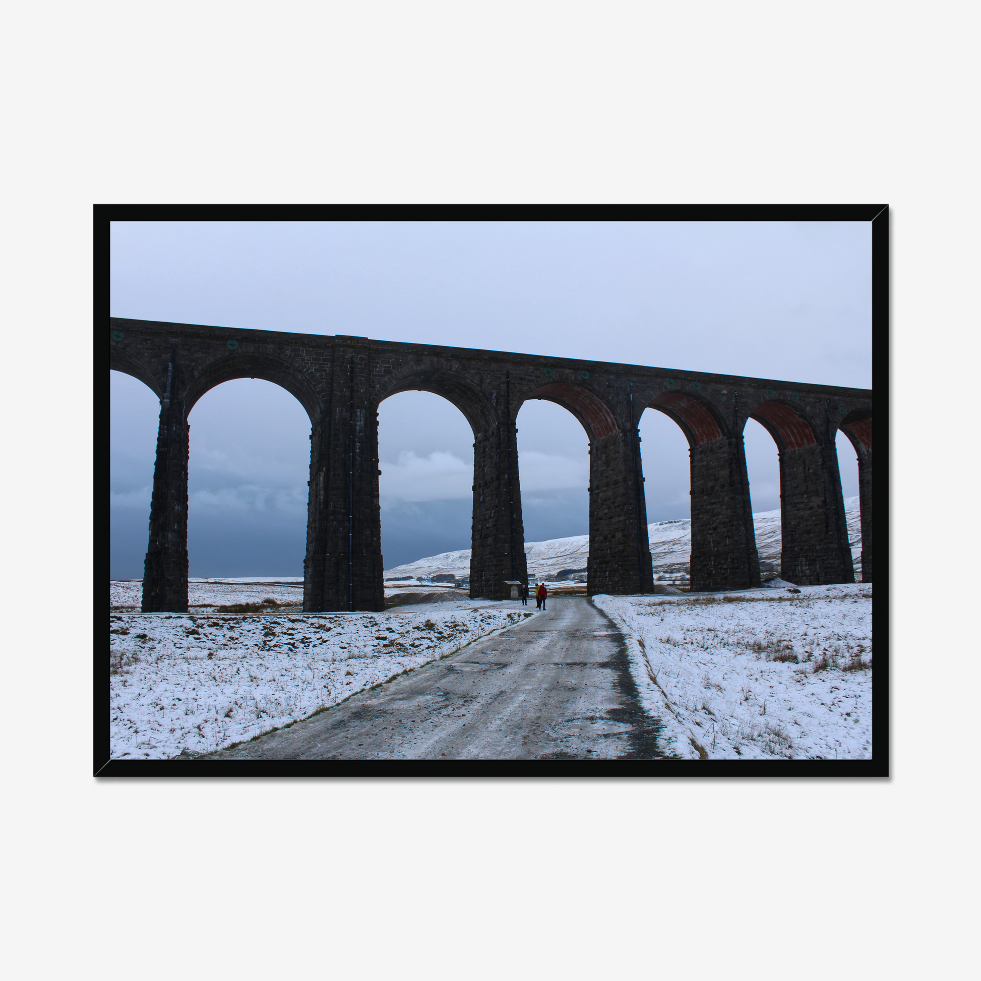 Framed photograph featuring the Ribblehead Viaduct in winter with snow on the ground and a cloudy sky.