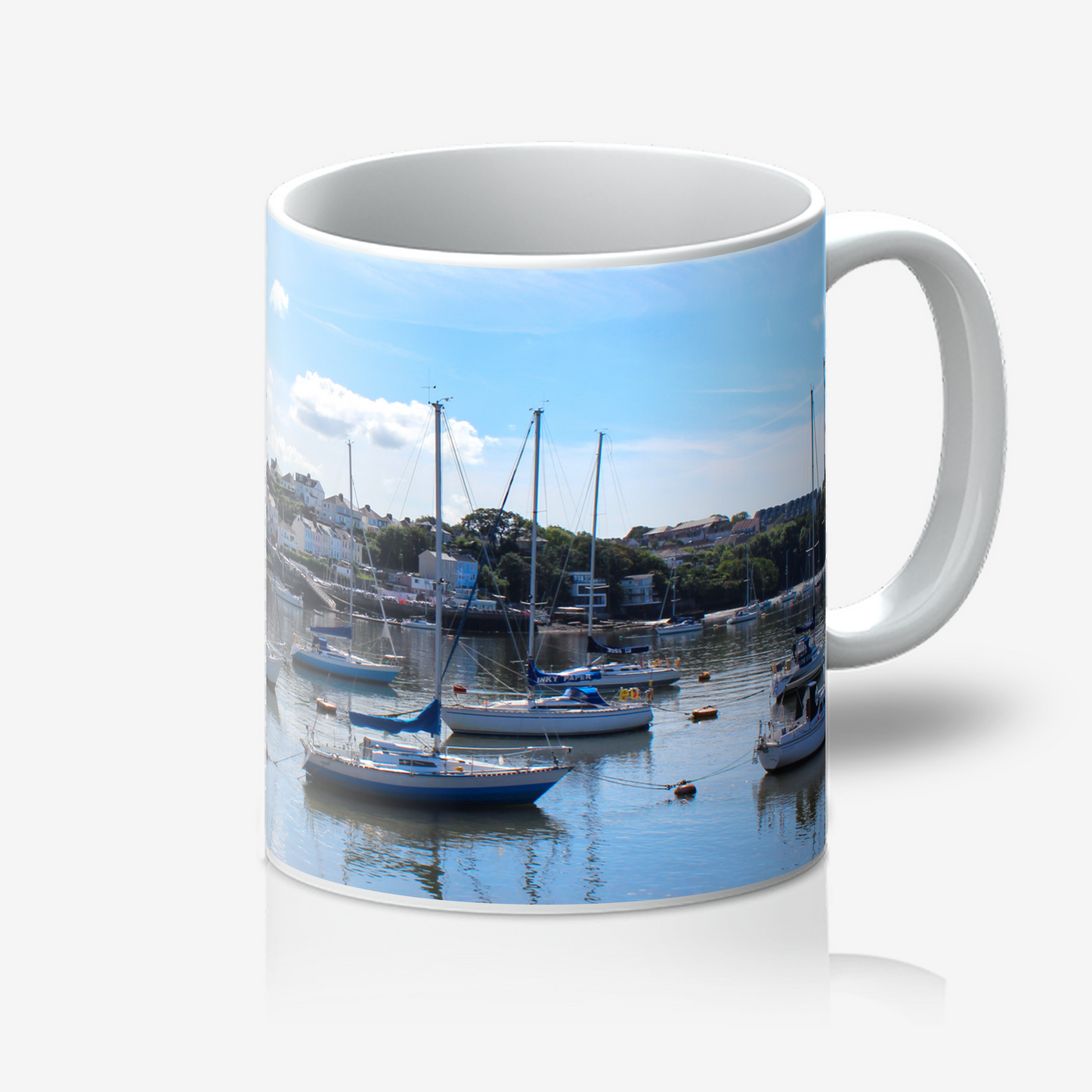 Mug with a scenic design of boats in a harbor on a white background