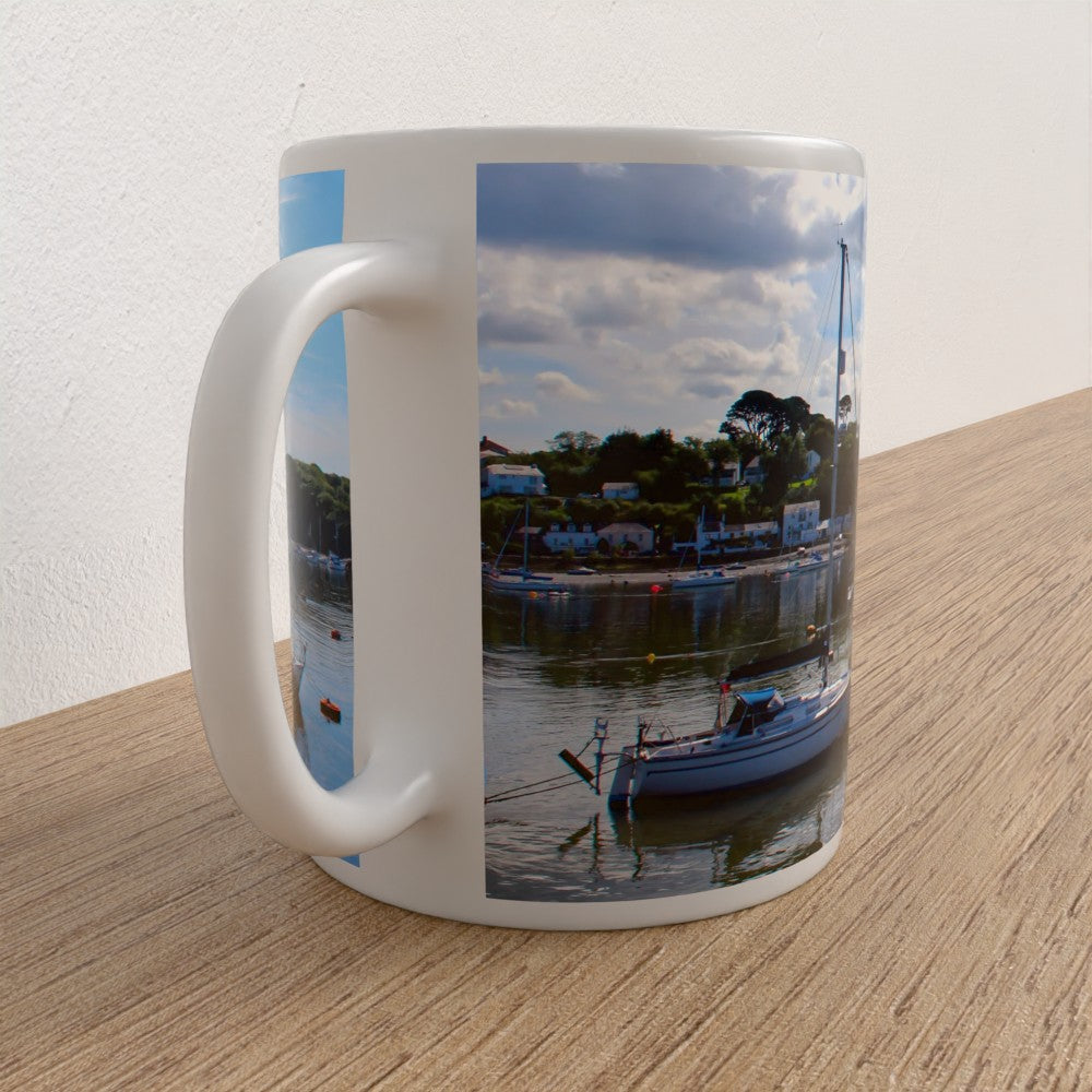 White mug with a scenic print of a harbor on a wooden surface