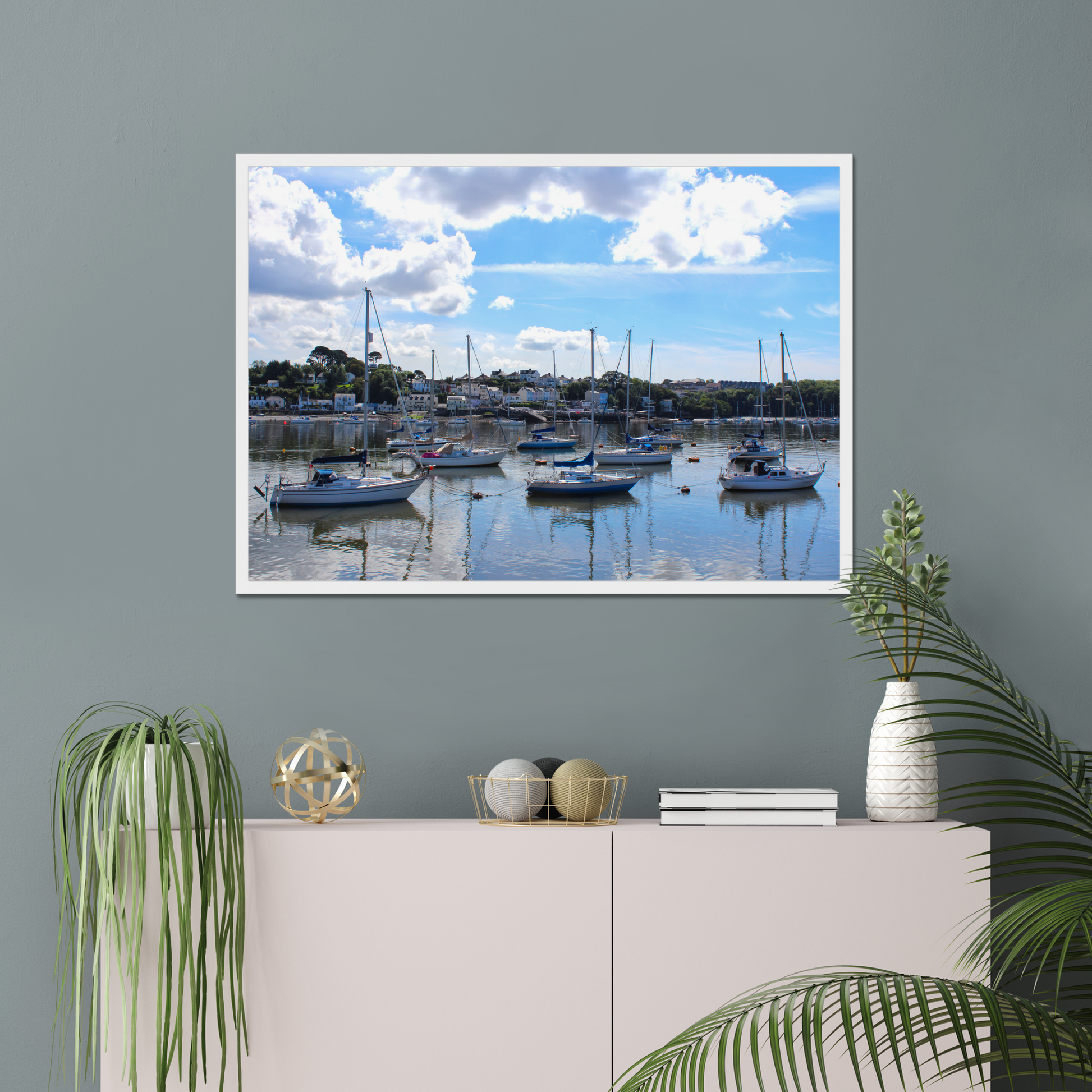 Framed photograph of a harbour scene with boats docked in calm water under a blue sky with clouds.