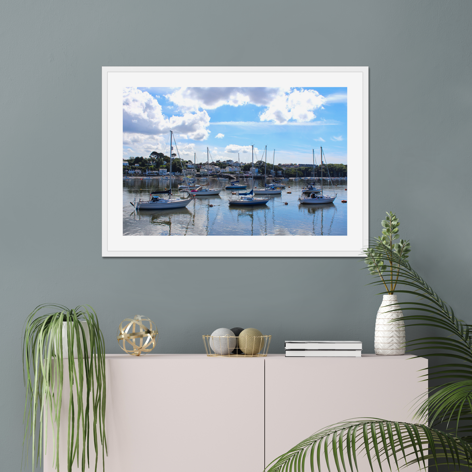 Framed photograph of a harbour scene with boats docked in calm water under a blue sky with clouds.