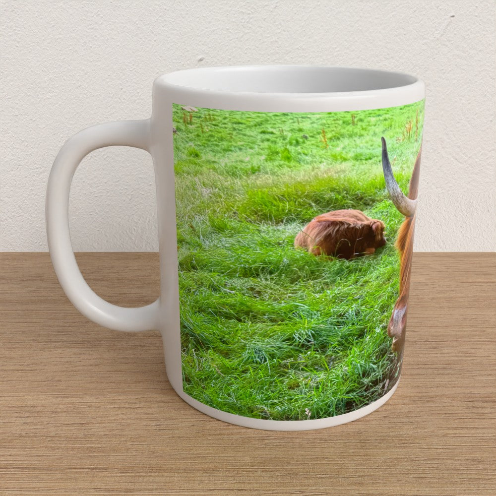 White mug with a printed design of a cow and calf on grass