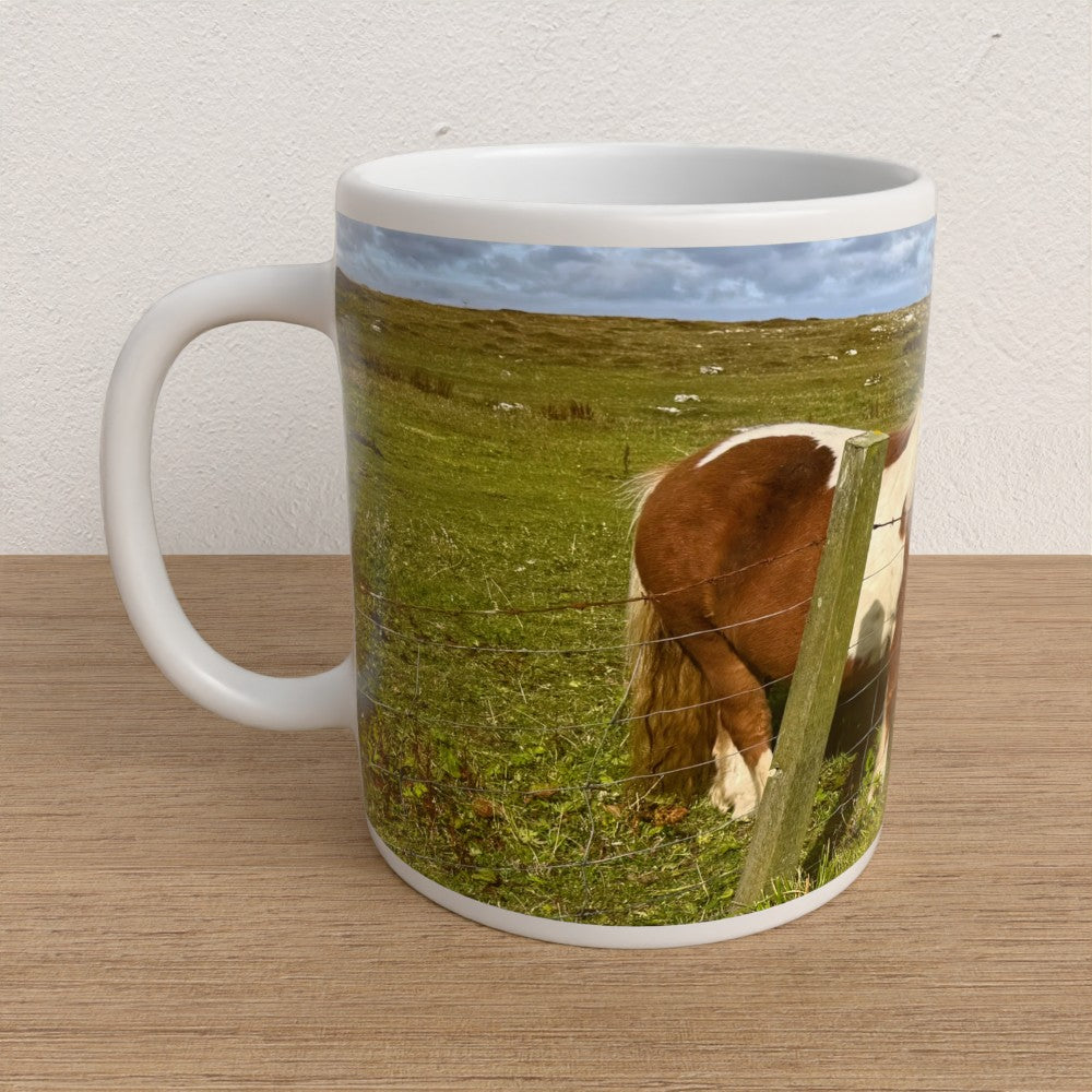 Mug with a horse in a field design on a wooden surface