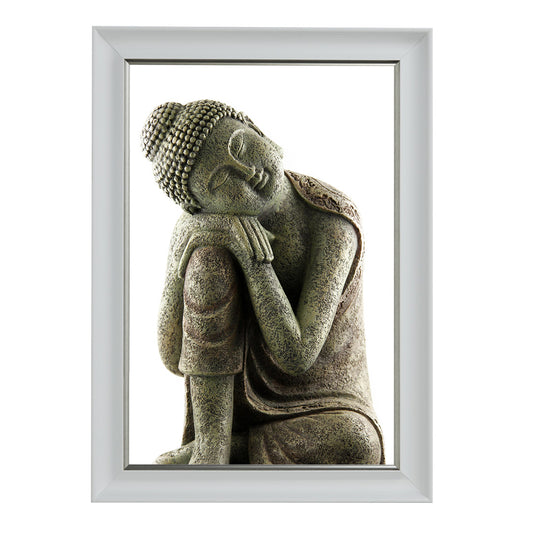 A white framed picture depicting a sculpture of a sleeping Buddha.