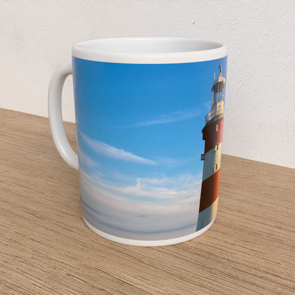 Mug with a lighthouse design on a wooden surface
