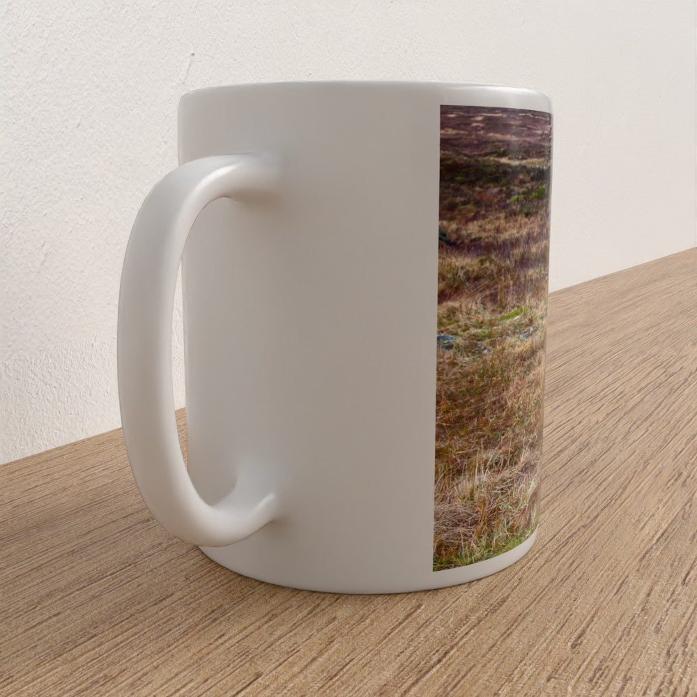 White mug with a nature-themed design on a wooden surface