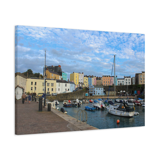 Harbour scene with colourful buildings and boats under a blue sky.
