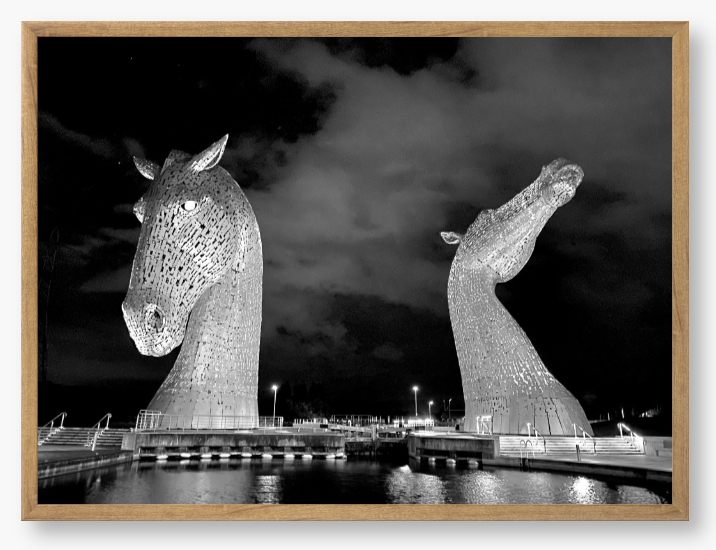 Black and White Framed Photo of the Kelpies horse sculptures in Falkirk, Scotland, illuminated at night. 