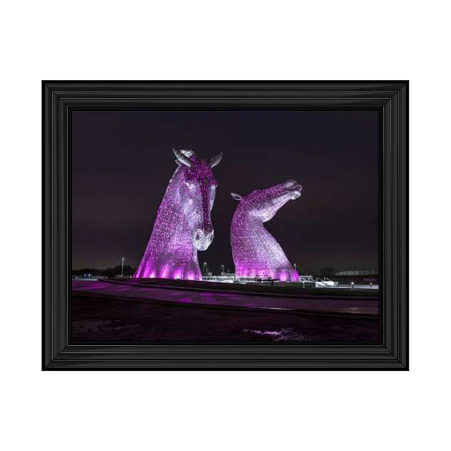 Framed wall art of the Kelpies lit up purple at night. 