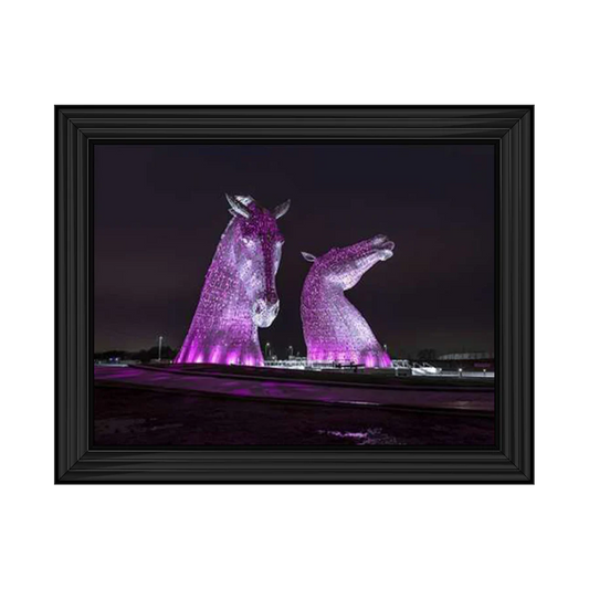 Framed wall art of the Kelpies lit up purple at night. 
