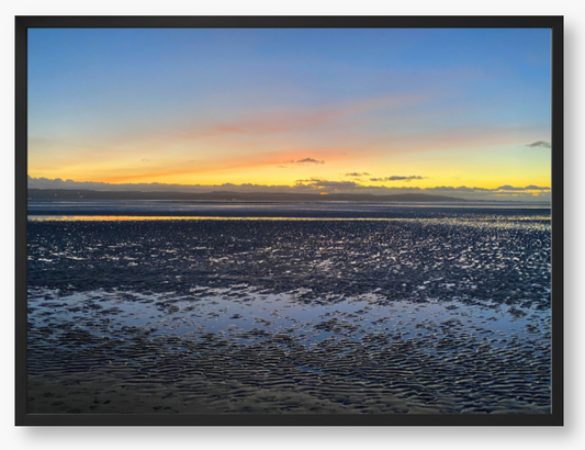 Framed Photo Of A Sunset over a calm body of water with a colorful sky.