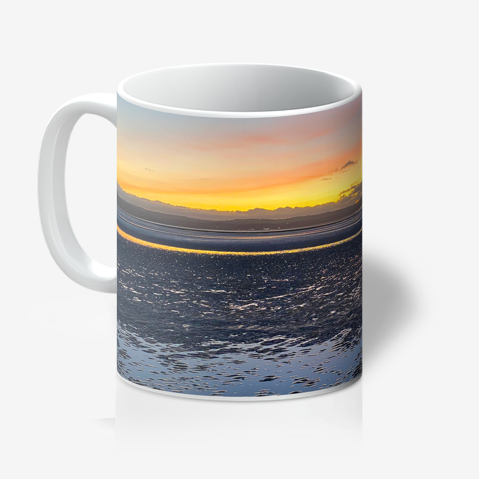 Mug with a sunset over water design on a white background