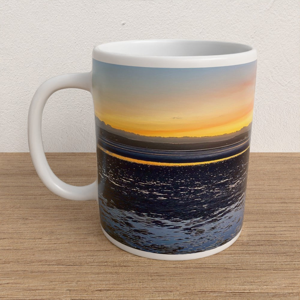 Mug with sunset and starry night design on a wooden surface